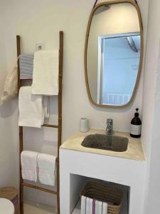 a bathroom with a sink with a mirror and towels at Casa Buganvilla in Alcácer do Sal