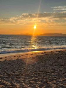 una playa con puesta de sol sobre el océano en Casa Buganvilla en Alcácer do Sal