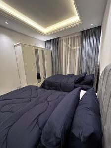 a bedroom with two beds with blue pillows at Self check in Unique 3 Bedrooms Apartment in Riyadh