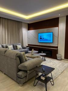 a living room with a couch and a flat screen tv at Self check in Unique 3 Bedrooms Apartment in Riyadh