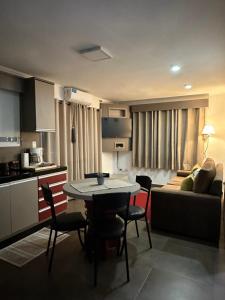 a kitchen and living room with a table and a couch at SOMBRAS DEL PARANA Apart Misiones in Eldorado