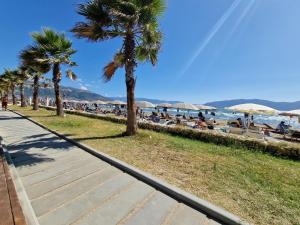 una spiaggia con palme e persone sulla spiaggia di JD villa a Vlorë