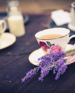 een kop koffie en een boeket bloemen op een tafel bij Finchingfield Lavender in Finchingfield