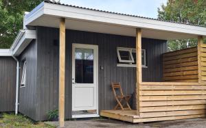 een klein huis met een veranda en een witte deur bij Gunnlaugsgata 3 in Borgarnes