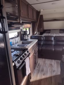 a kitchen with a stove and a couch in an rv at Branson RV Park in Branson