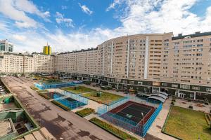 eine Luftansicht auf ein großes Gebäude mit einem Tennisplatz in der Unterkunft Жк Нурсая вблизи Байтерека in Astana