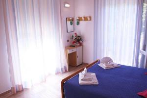 a bedroom with a blue bed with two towels on it at Hotel Colorado in Rimini