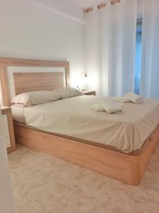 a bedroom with a large bed with a wooden frame at Benidorm Carolina Beach & Pool in Benidorm