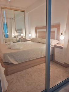 a bedroom with a large bed and a mirror at Benidorm Carolina Beach & Pool in Benidorm