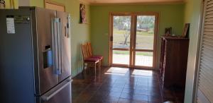 a kitchen with a refrigerator and an open door at Standard Queen size bedroom in Little River