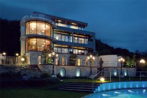 - un grand bâtiment avec une piscine en face dans l'établissement Villa via Lapis - Panoramablick über Dresden - Garten - Pool - Sauna - Luxus, à Dresde