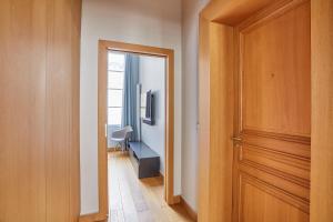 a hallway with a door to a room with a television at Apartment Ile Saint Louis by Studio prestige in Paris