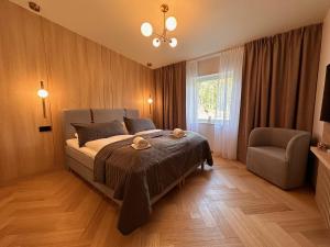 um quarto com uma cama, uma cadeira e uma janela em Big River Camp Hotel & Spa em Föllinge