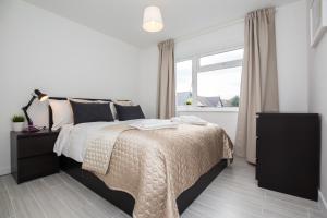 a bedroom with a bed and a window at Stylish and Cosy 1 BDR Apt, Ealing Broadway in London