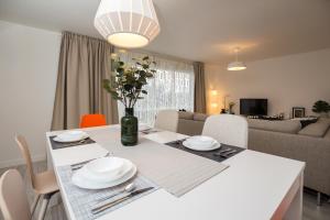 a white dining room table with plates and flowers on it at Stylish and Cosy 1 BDR Apt, Ealing Broadway in London
