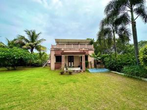 a small house in a field with a yard at Farm stay in Ahmedabad in Ahmedabad +13 photos