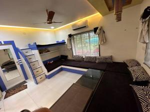 een woonkamer met een bank en een raam bij Farm stay in Ahmedabad in Ahmedabad