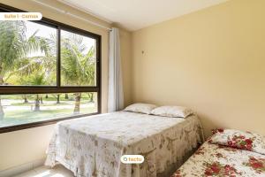 a bedroom with a bed and a window at Térreo completo e gigante VG Sun Cumbuco por Tactu in Cumbuco