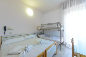 een slaapkamer met 2 bedden en handdoeken bij Hotel Colorado in Rimini