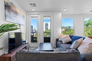 sala de estar con sofá y TV de pantalla plana en 2BR Escape Balcony Gym and Premier Comfort en Salt Lake City