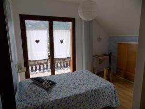 a bedroom with a bed and a window with hearts on the curtains at LA ROCCA BIANCA in Demonte