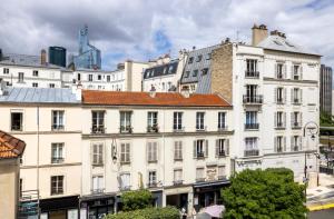 a large white building in front of a city at Hotel Charlemagne in Neuilly-sur-Seine