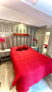 a bedroom with a large red bed with red pillows at CASA CENTRICA - experiencia casa pasillo paseo del siglo in Rosario