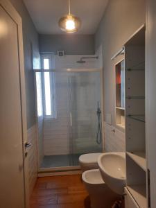 a bathroom with a shower and a toilet and a sink at LUCIETTA 60 HOUSE in Florence