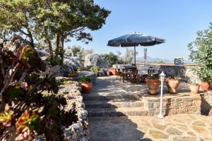 un patio con sombrilla, mesa y sillas en Sunlight Residence en Kalo Chorio
