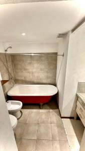 a bathroom with a bath tub and a toilet at CASA CENTRICA - experiencia casa pasillo paseo del siglo in Rosario