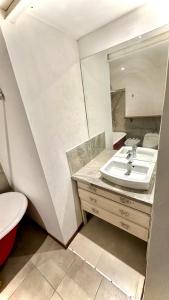 a bathroom with a sink and a toilet and a mirror at CASA CENTRICA - experiencia casa pasillo paseo del siglo in Rosario