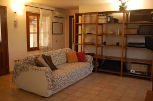 un soggiorno con divano e cuscini sopra di Casa Vacanze La Rosa e L'Ulivo a Faiti