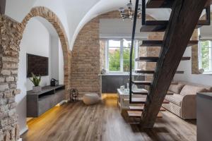 a living room with a staircase and a brick wall at Cozy Carmelite apartment in Vilnius