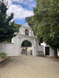 um edifício branco com um portão e um banco em Ubytování u Zuzy em Velké Pavlovice