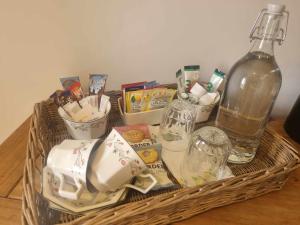 a basket with dishes and a bottle on a table at Coves House Farm B&B in Wolsingham