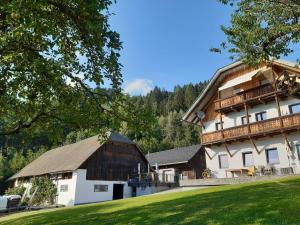 a large white building with a large wooden barn at Appartement Fromme Helene in Millstatt
