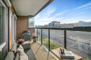 a balcony with a couch and a large window at Rose in Sandvika