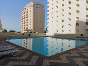 a swimming pool in front of two buildings at Varandas da Rocha in Portimão