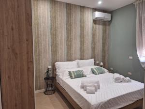 a bedroom with a large bed with towels on it at DOMUS 0143 in San Giorgio Ionico