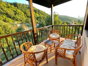 a balcony with chairs and a table with a view of the mountains at Kassandrova Guest House & Spa in Bratsigovo