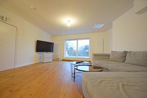 een woonkamer met een bank en een flatscreen-tv bij Air Apartments 14 in Bremen