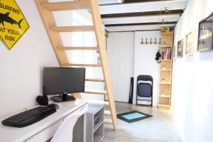 Habitación con escritorio, ordenador y escalera. en Https en Andenne