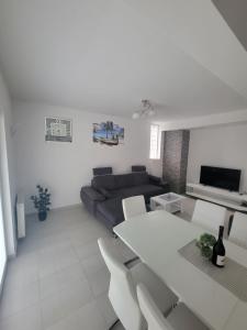 Sala de estar blanca con sofá y mesa en Residence Horvat, en Grkavešćak