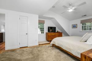 a white bedroom with a bed and a tv at 55 Wianno Circle Osterville - O Captain My Captain in Osterville