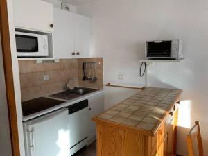 a small kitchen with a sink and a microwave at Paradiski ski au pied vallandry in Landry