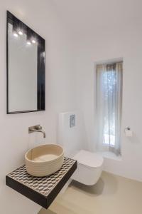 a bathroom with a sink and a toilet and a mirror at Luxury Villa Gialova Neokastro with Private Pool in Gialova