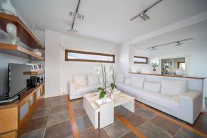 a living room with a white couch and a tv at Villa Blasco by MZ Villas in Puerto Calero