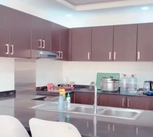 a kitchen with brown cabinets and a counter top at Al Sharq Holiday Home in Khor Fakkan