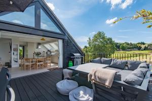 eine Terrasse mit einem Sofa und einem Tisch auf einer Terrasse in der Unterkunft The Hayloft by Bloom Stays in Canterbury