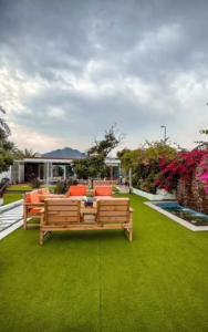 a garden with a bench on a green lawn at Al Sharq Holiday Home in Khor Fakkan